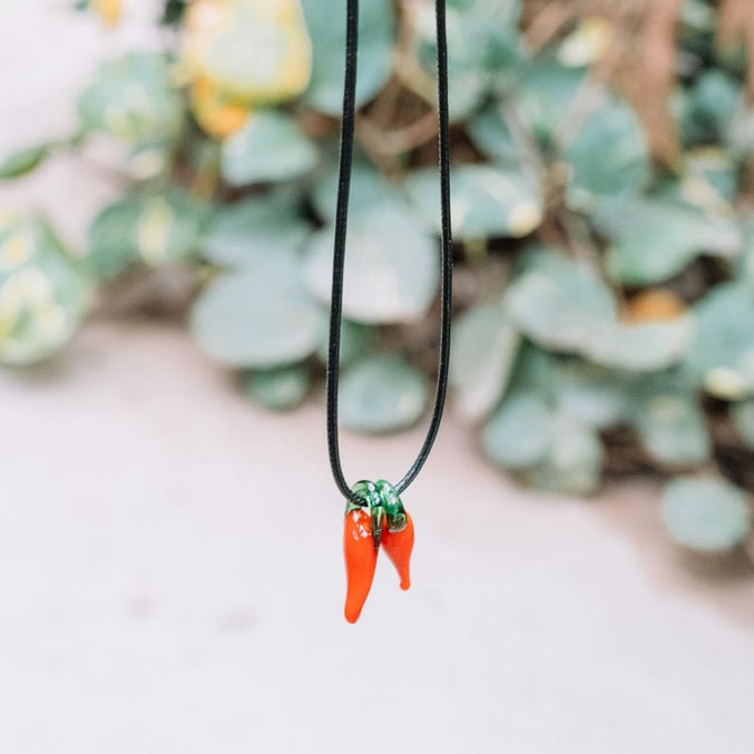 Mooie zwarte ketting met twee glazen pedis (peper) hangertjes eraan. 